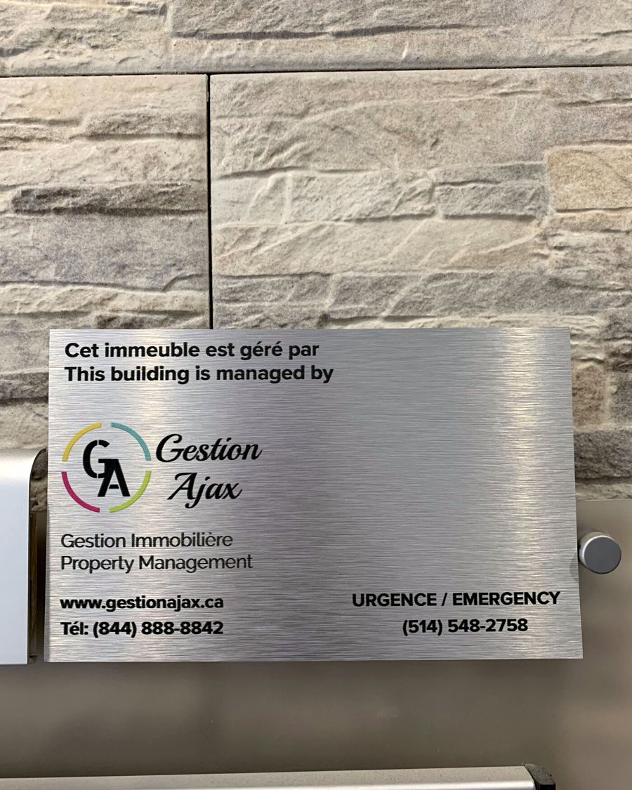 Plaque Gestion Ajax sur une façade en pierre